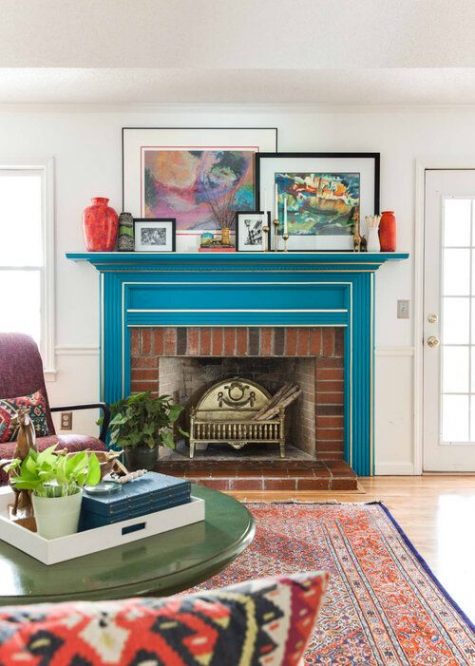 a bright mid century modern living room with a bold blue mantel over a red brick fireplace, the mantel completely changes the look