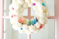 20 a fluffy white pompom Christmas wreath with colorful ornaments and matching bottle brush trees is a fun touch to your space