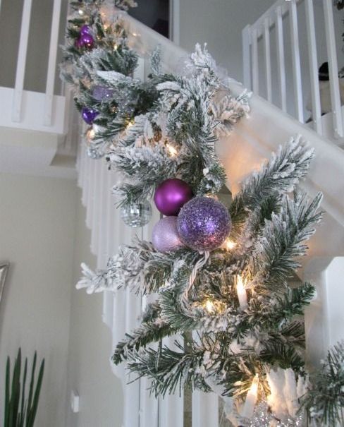 a flocked evergreen garland with lights, purple, blush and lilac ornaments is amazing for Christmas decor in your home
