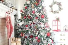 21 a lovely flocked Christmas tree with red, silver, buffalo check ornaments, stars, snowflakes and berry branches on top