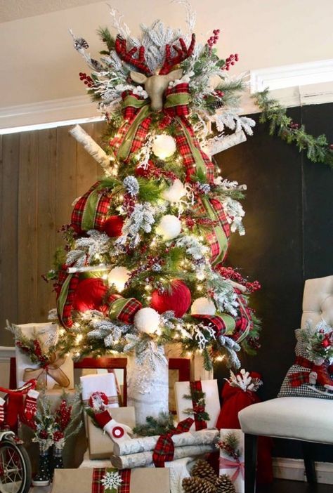 a jaw-dropping Christmas tree decorated with red and white ornaments and red plaid ribbons, with a faux deer head and berries on top