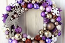 23 a pretty bright Christmas wreath with lilac, purple, silver and gold ornaments, tiny pinecones and a rhinestone deer is a lovely and bold front door decoration