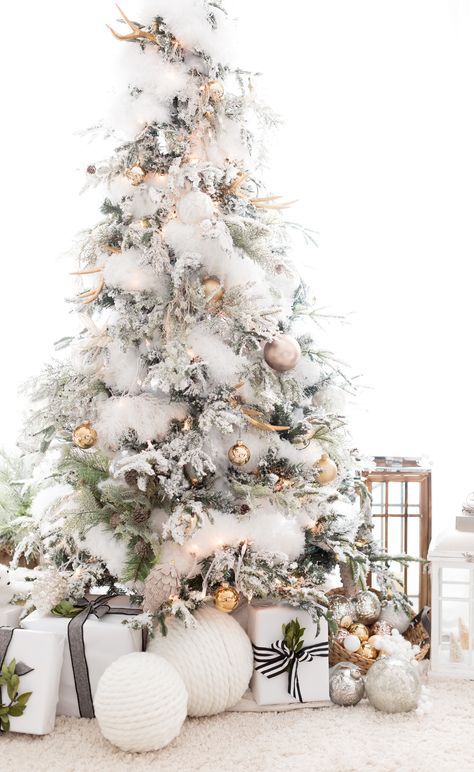 an enchanting Christmas tree with gold and copper ornaments, natlers, white faux fur garlands, antlers and pinecones is veyr glam like