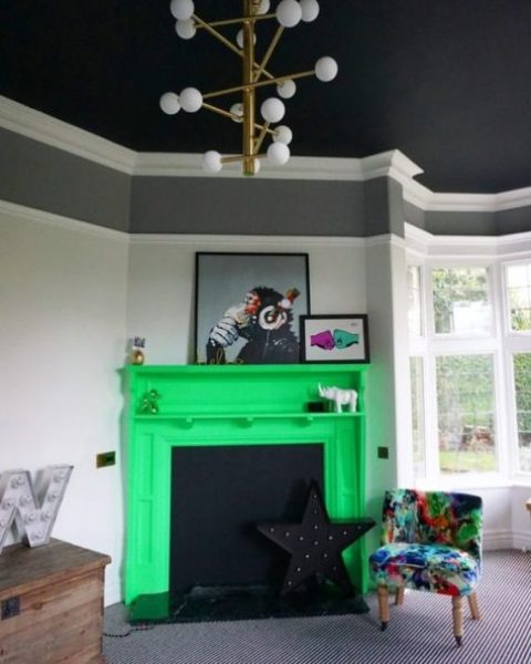 a moody living room spruced up with a neon yellow faux fireplace and a colorful printed chair