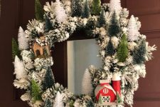 26 a lovely snowy Christmas wreath with white and green bottle brush Christmas trees and some houses is cute