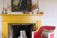 26 a red brick fireplace clad with a bold yellow mantel and a bright red and white vintage chair, some vases and candleholders