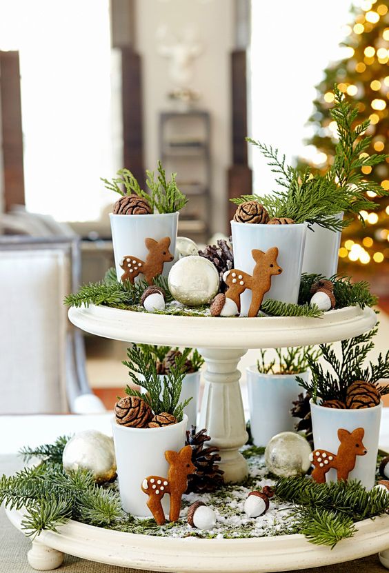 a pretty forest themed Christmas centerpiece of pinecones, evergreens, little metallic baubles, deer cookies and acorns
