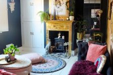 27 a refined eclectic living room with black walls, a refined black daybed, sophisticated furniture, a black heart with a gold mantel