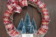 27 a vine and plaid ribbon Christmas wreath with green bottle brush trees and a tree farm sign is a cozy idea