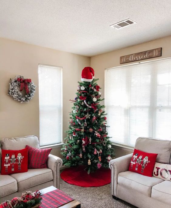 a red Santa hat with a pompom is always a good and fun topper idea for a red and white Christmas tree