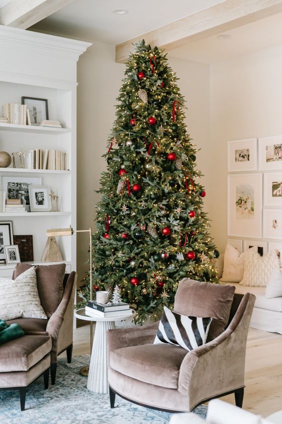 a beautiful Christmas tree with gold, red and dark green ornaments and lights is a fresh take on the traditional color scheme