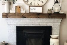 30 a vintage farmhouse fireplace of whitewashed brick, a dark-stained wooden mantel with pretty vintage decor