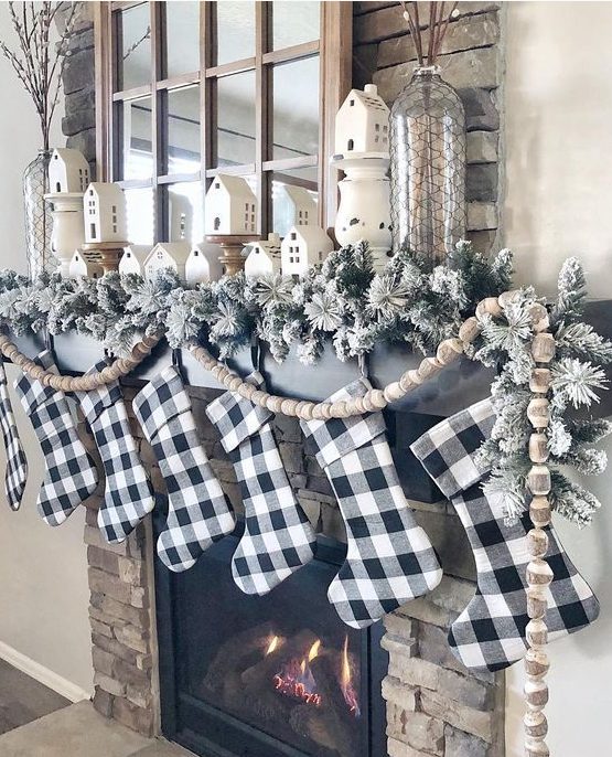buffalo check stockings, flocked evergreens and wooden bead garlands for Christmas mantel decor