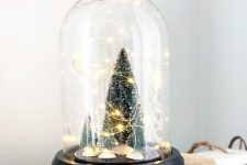 32 a small and cute Christmas terrarium with bottle brush Christmas trees and lights is a cool decor idea