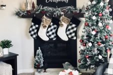 32 white and buffalo check stockings with faux fur, a buffalo check bow on top the tree and maching ribbons on the mantel