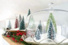 33 a vintage cloche with faux snow and green bottle brush trees is a lovely Christmas decoration