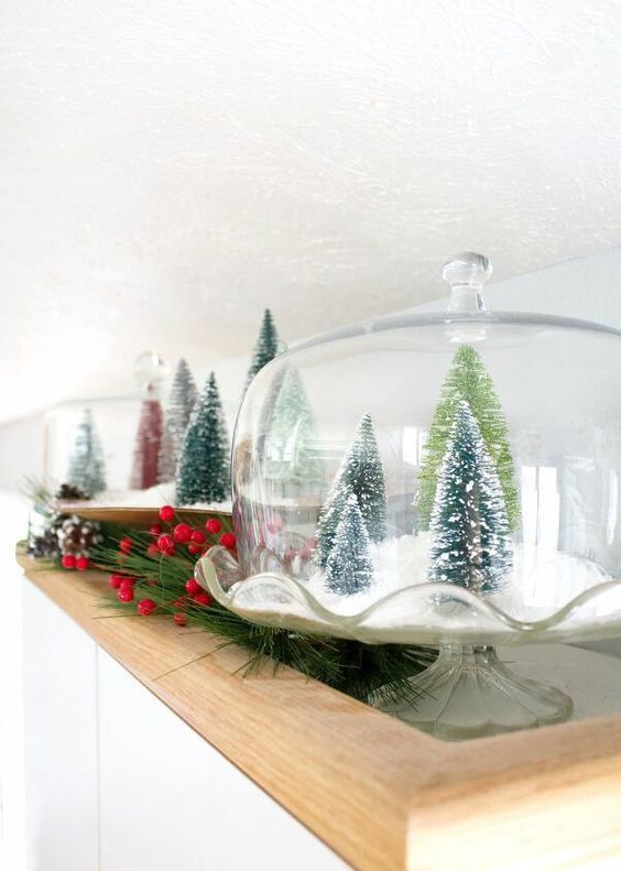 a vintage cloche with faux snow and green bottle brush trees is a lovely Christmas decoration