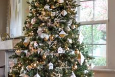 36 a modern glam Christmas tree with white and gold ornaments, faceted rhomb ornaments, stars and mini houses is cool