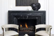 37 a catchy fireplace nook with a black marble clad fireplace, refined chairs and a black marble side table