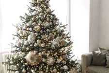 39 a jaw-dropping Christmas tree with silver, gold and glitter ornaments and oversized disco balls plus lights is ideal for party lovers