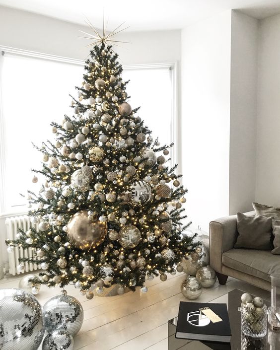a jaw-dropping Christmas tree with silver, gold and glitter ornaments and oversized disco balls plus lights is ideal for party lovers