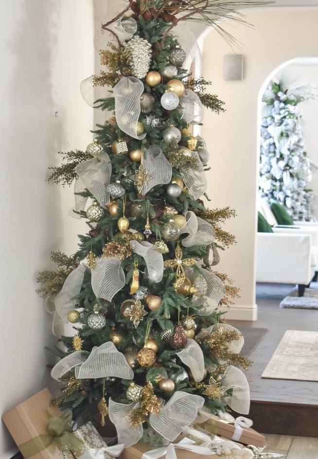 a glam Christmas tree with silver, gold, grey, brown ornaments, gilded branches, pinecones, neutral ribbons and branches is a unique idea