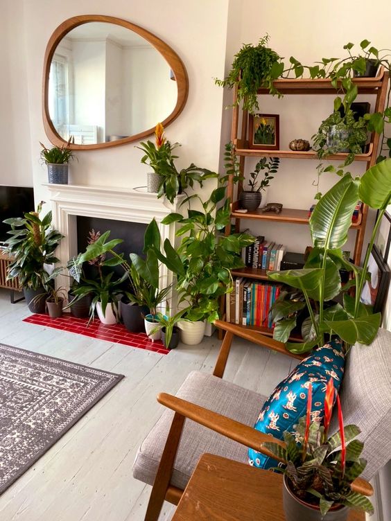 a beautiful biophilic living room with lots of statement potted plants here and there including the non-working fireplace