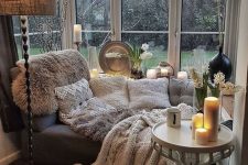 53 a gorgeous window nook with a daybed styled with lots of textural pillows and blankets, pampas grass and a lamp with a burlap shade