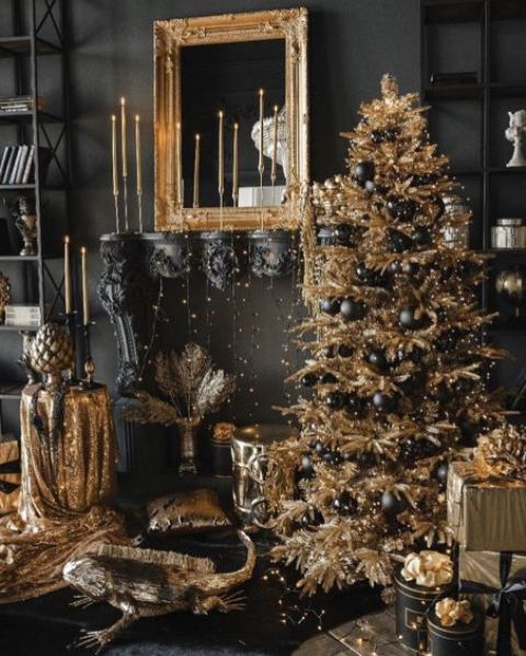 a shiny gold Christmas tree with lights and glossy and matte black ornaments is a gorgeous idea for a glam holiday space