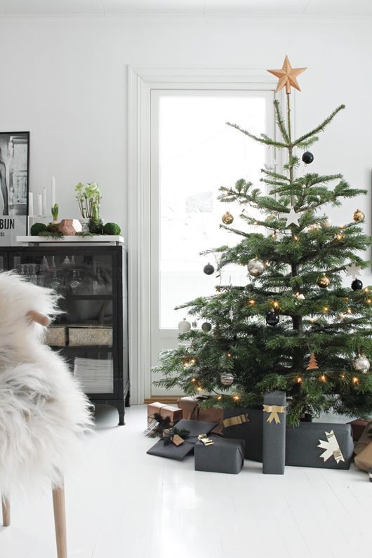 a simple and glam Christmas tree with black, silver and gold ornaments, a star tree topper and lights is a refined and simple idea