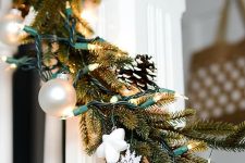 a Christmas garland of evergreens, ornaments, lights, stars, snowflakes is a cool decor idea for a mantel or banister