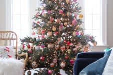 a Christmas tree with lights and colorful vintage ornaments and a bold tree skirt is a fantastic decor statement