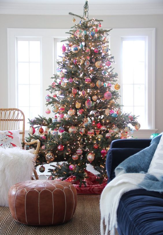 a Christmas tree with lights and colorful vintage ornaments and a bold tree skirt is a fantastic decor statement