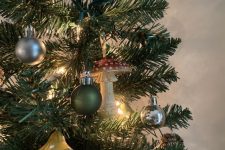 a Christmas tree with lights, mushrooms, ornaments and pinecones is a lovely idea for a woodland Christmas space