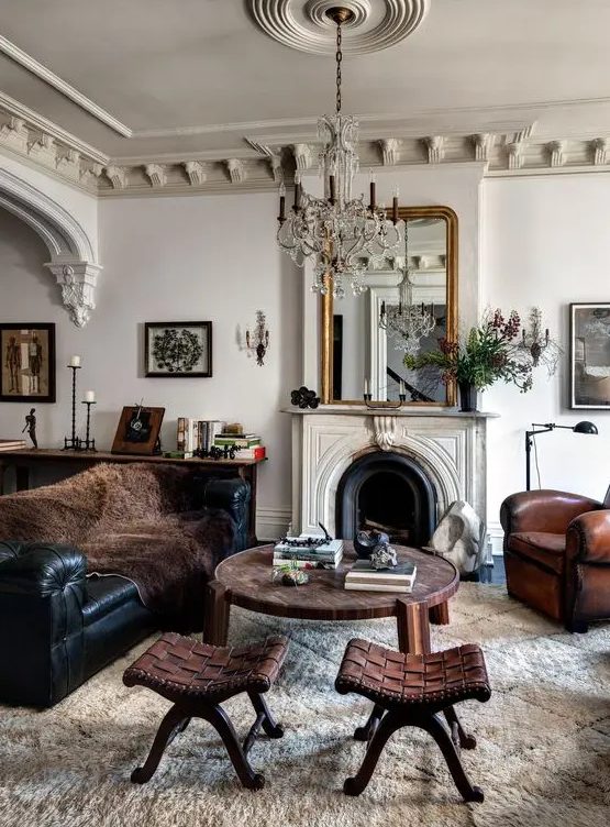a beautiful French chic living room with sculptural crown molding and a classic medallion, with leather furniture and a non-wokring fireplace