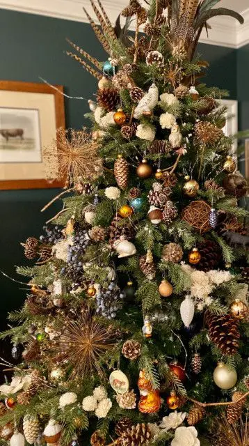 a boho woodland Christmas tree with feathers, ornaments, pinecones, faux birds and rabbits is a lovely idea