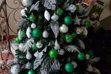 a bold Christmas tree with white, silver and emerald ornaments, leaf and feather ornaments, beads and lots of glitter