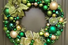 a bold green and gold Christmas ornament wreath with fabric blooms, snowflakes and a large bow is a stylish idea to rock