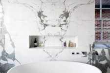 a bright contemporary bathroom done with white and grey tiles, a modern oval tub and windows
