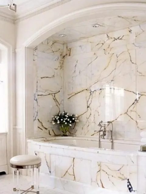 a chic and refined bathroom with a tub space all clad with catchy marble panels