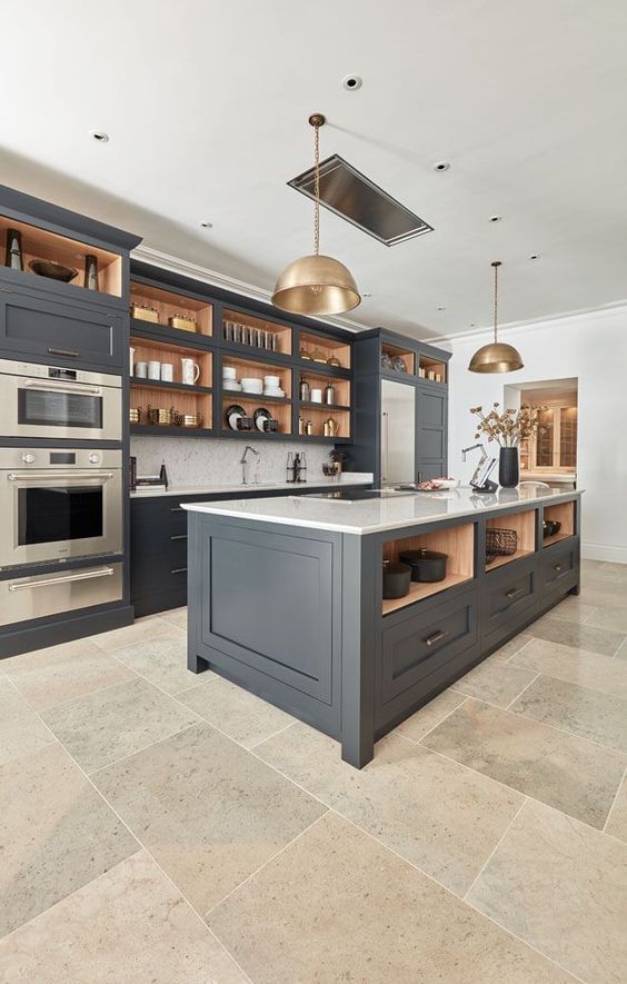 a chic and refined dark grey kitchen with shaker cabinets, white stone countetops, white tiles and brass pendant lamps is cool