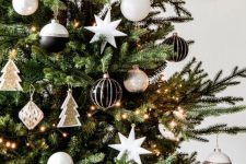 a chic and refined modern Christmas tree decorated with black, silver and white ornaments, little gold Christmas tree ornaments and paper balls