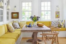 a colorful dining room with a bright yellow corner velvet banquette seating