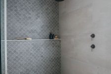 a contemporary bathroom done with neutral concrete on the walls and floor, grey concrete imitating fish scale tiles on one accent wall