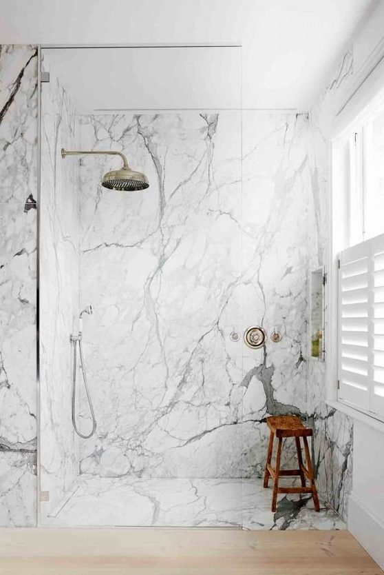 a contemporary bathroom with white marble, sleek wood and vintage hardware for a bright and chic look