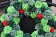 a cool Christmas wreath of pompoms of various shades of green and red is a very Christmassy craft and decoration to rock