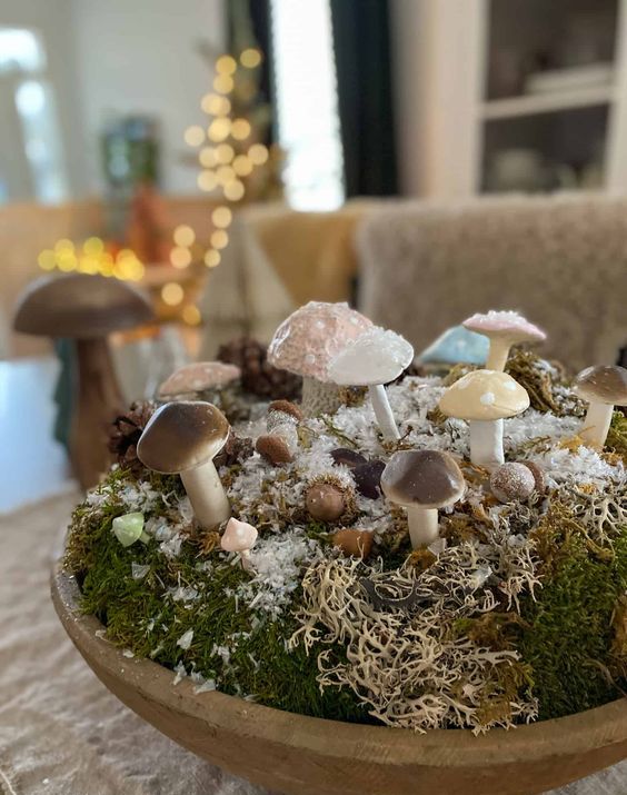 a cool woodland Christmas decoration of a wooden bowl with moss, faux snow and little mushrooms is a cool solution