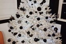 a stylish white christmas tree with black ornaments