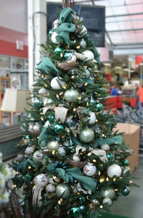 a dreamy Christmas tree with white and light green ornaments, dark green ribbons, acorns and lights plus faux birds in nests is wow