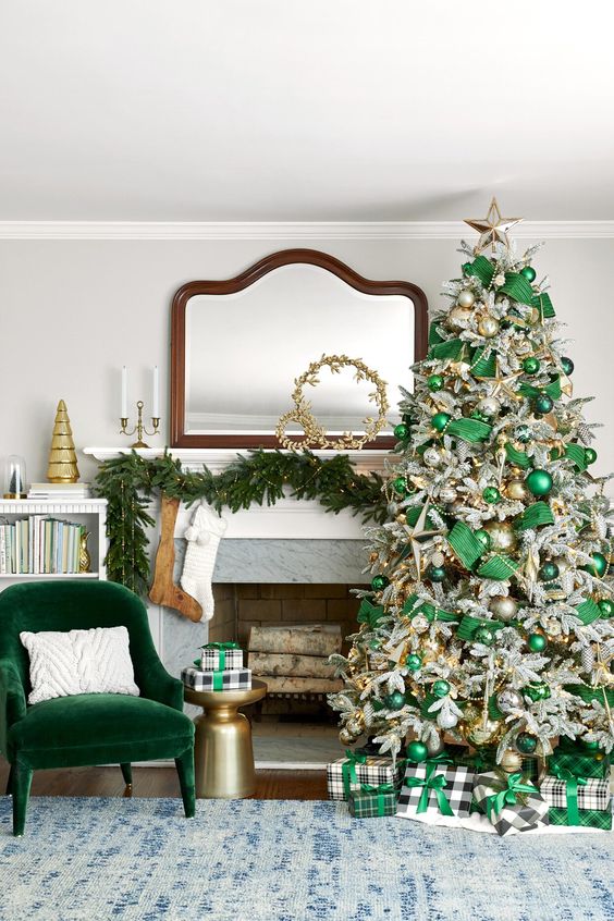 a fabulous Christmas space with an emeralf velvet chair, an evergreen pre-lit garland, a flocked Christmas tree with emerald ribbons and ornaments, beads and lights
